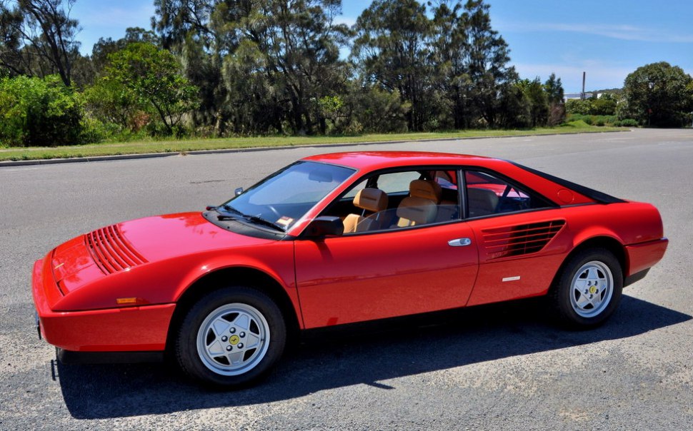 Classic wedge-shaped sports coupe with distinctive side air vents and a bright red exterior