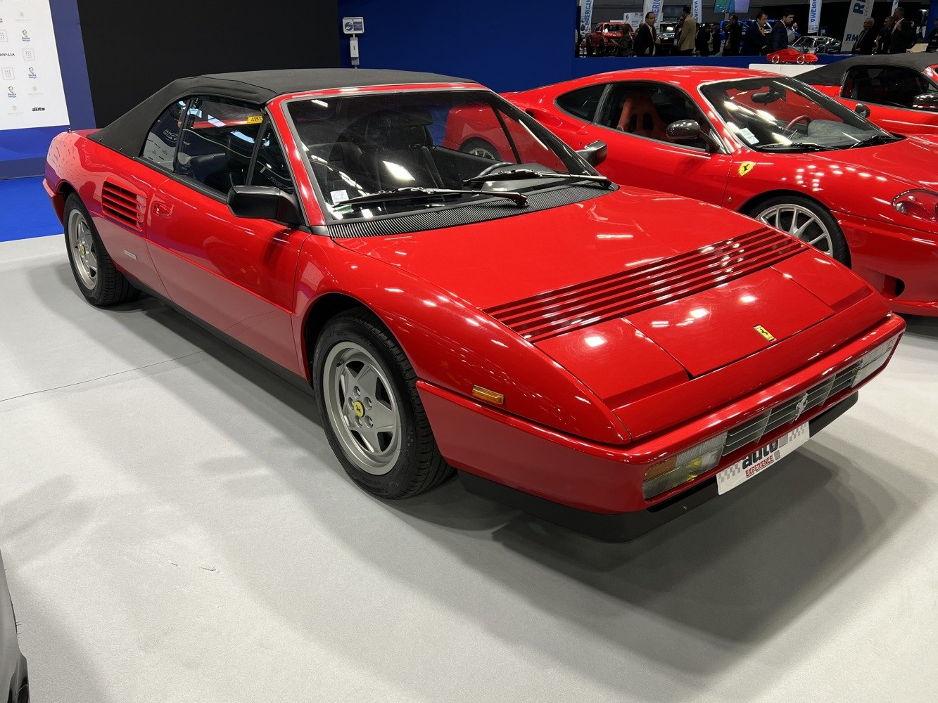 Red classic convertible with black soft top and side vents