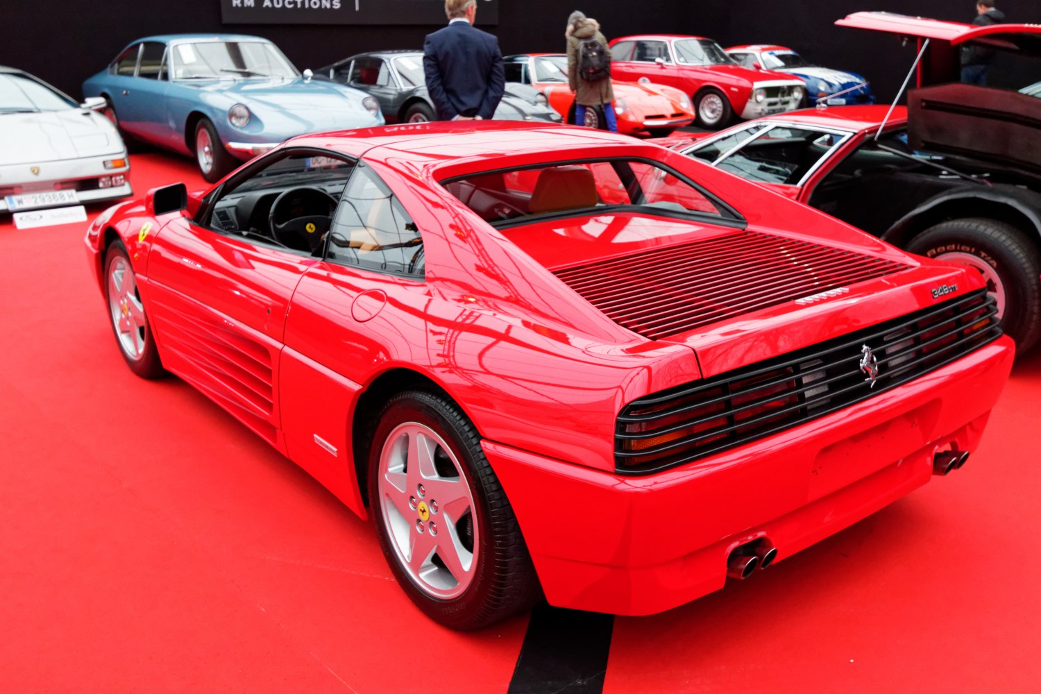 Rear grille, side air intakes, and five-spoke alloy wheels on a red sports car