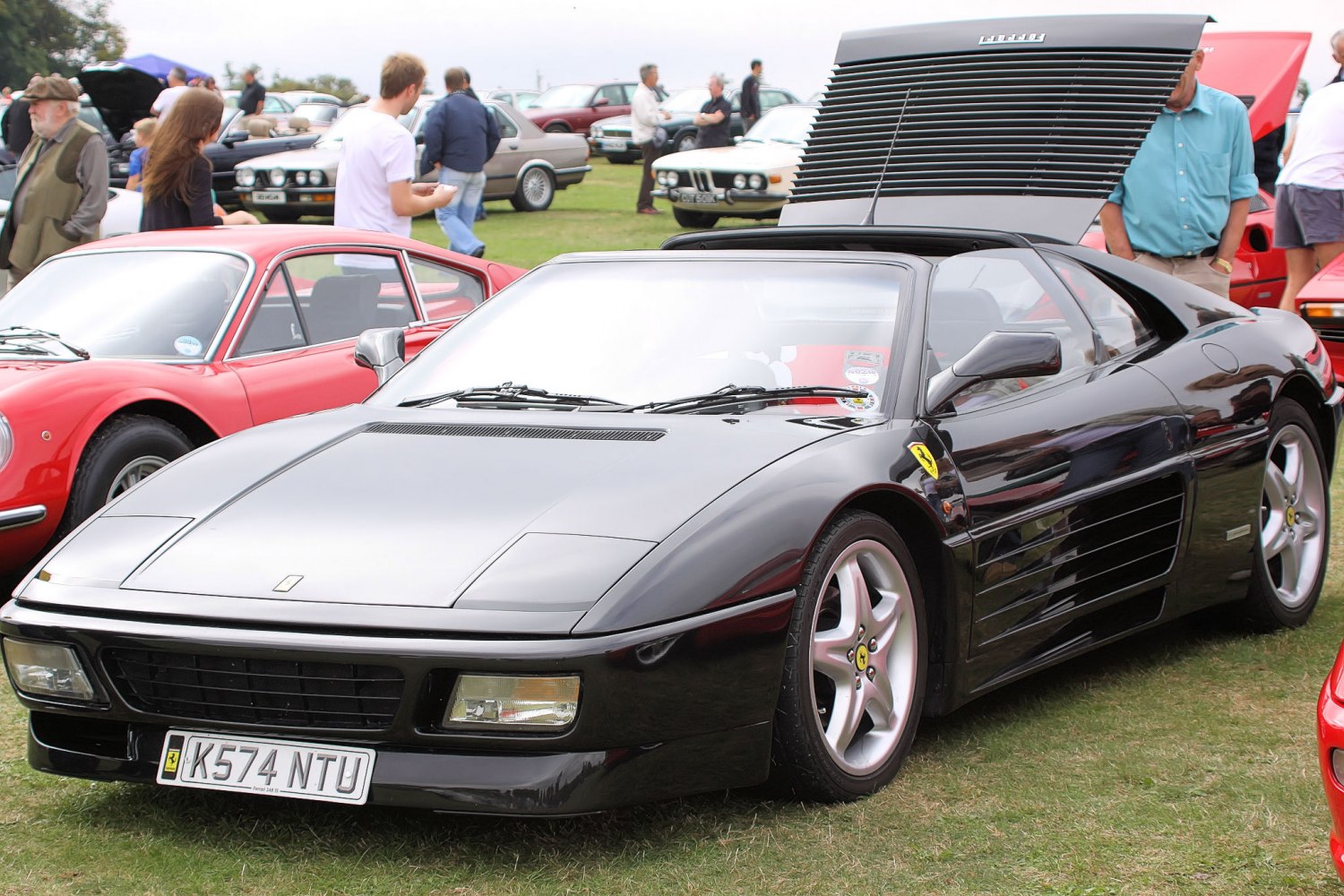 Black sports car with targa roof and open rear engine louvers