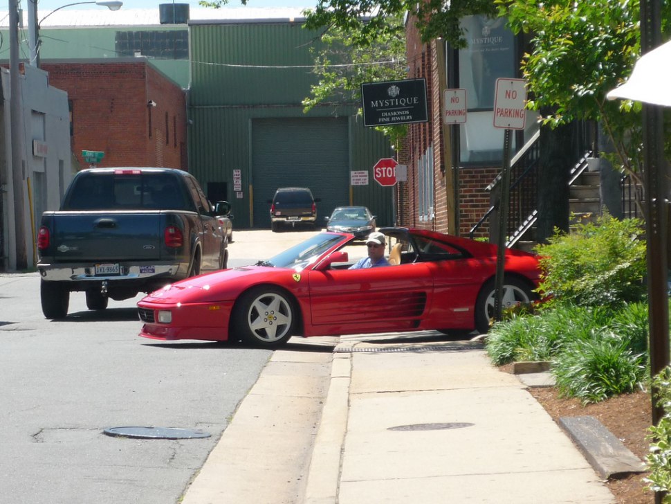 Red convertible sports car with distinctive side vents parked in urban environment