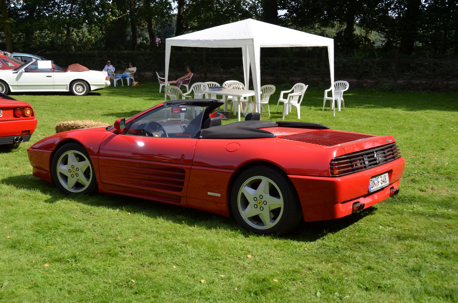 Red convertible sports car with five-spoke wheels and rear ventilation