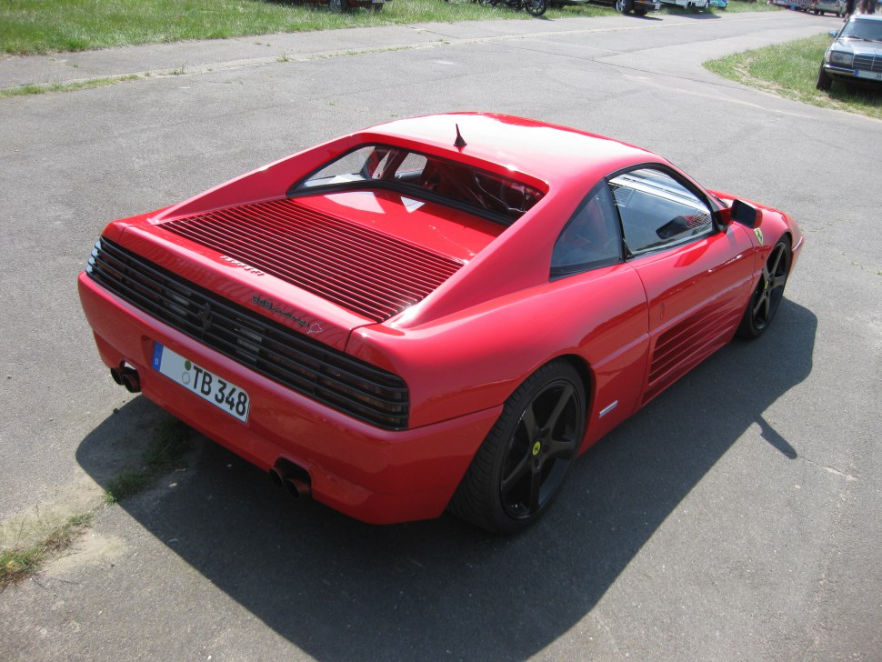 High-angle rear side view with black wheels and rear louvers.