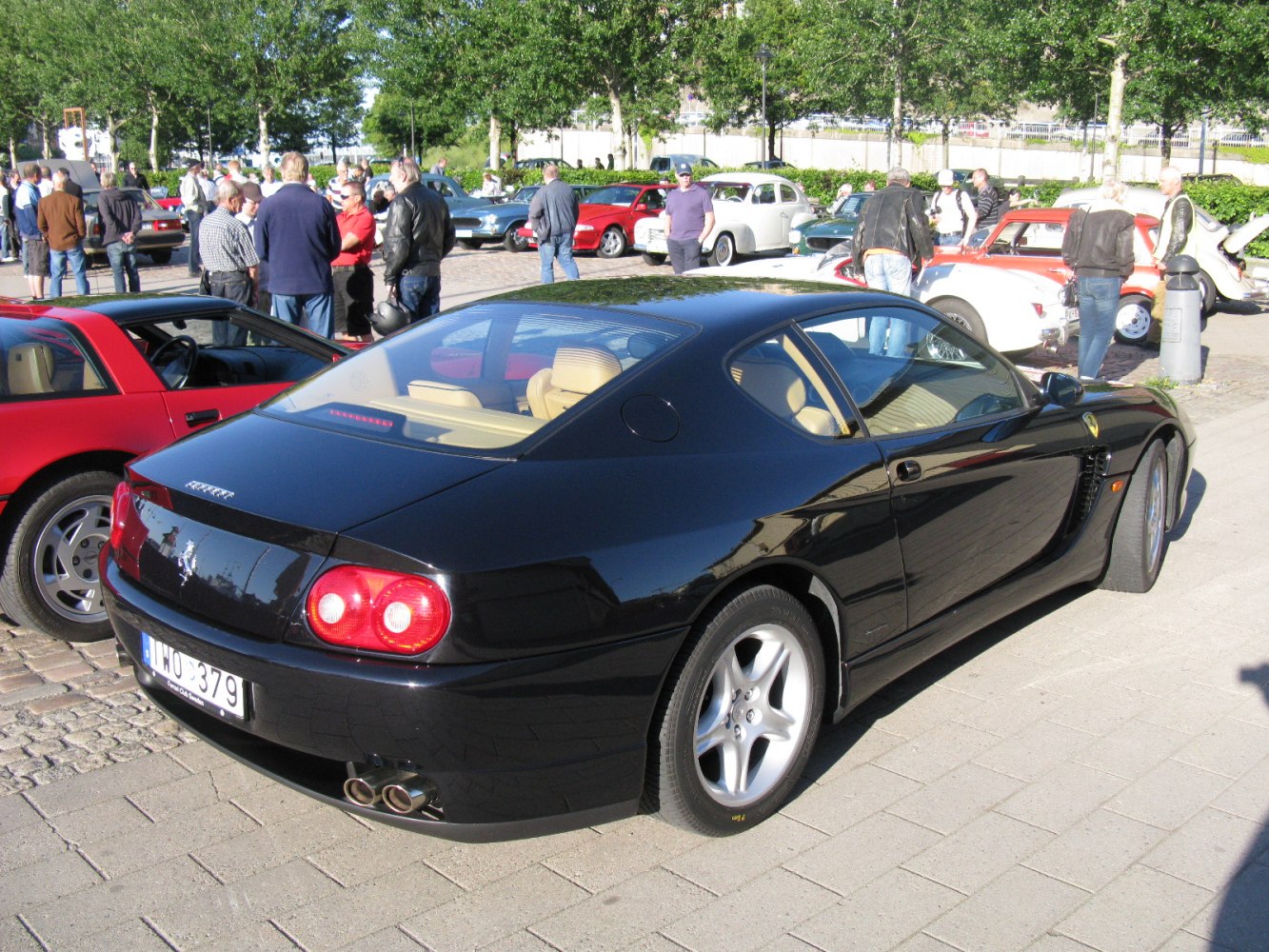 Black coupe rear with dual exhaust and tan interior