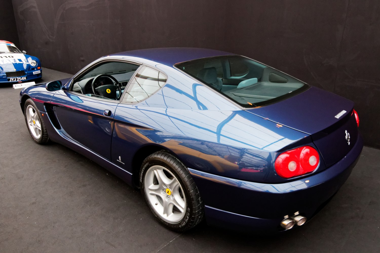 Rear-side view of a sleek sports coupe with distinctive taillights and dual exhaust