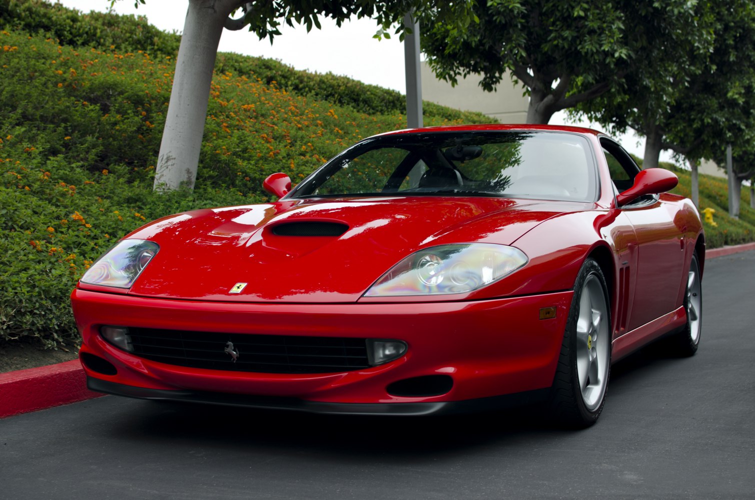 Red sports coupe with central hood scoop and distinctive rounded headlights