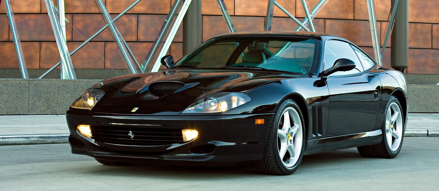 Black sports coupe with hood scoop and alloy wheels