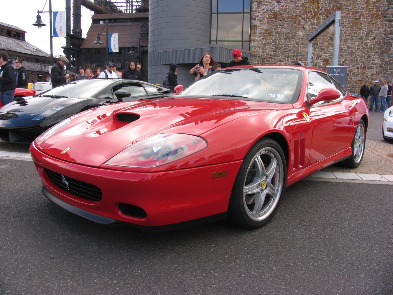 Front-side view of red sports car with hood scoop and alloy wheels