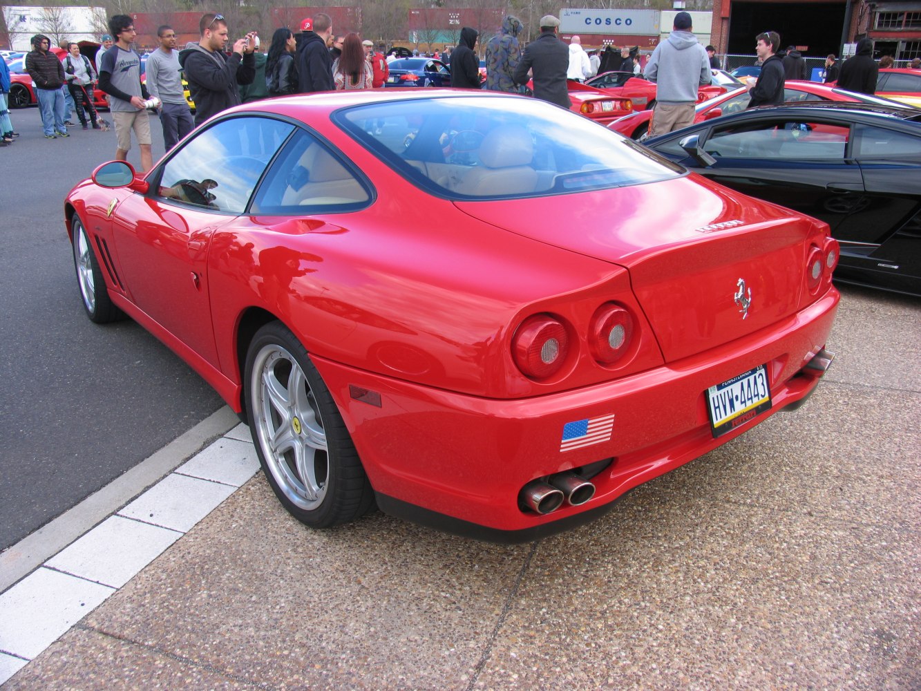 Rear view of red sports coupe with circular taillights and quad exhaust pipes