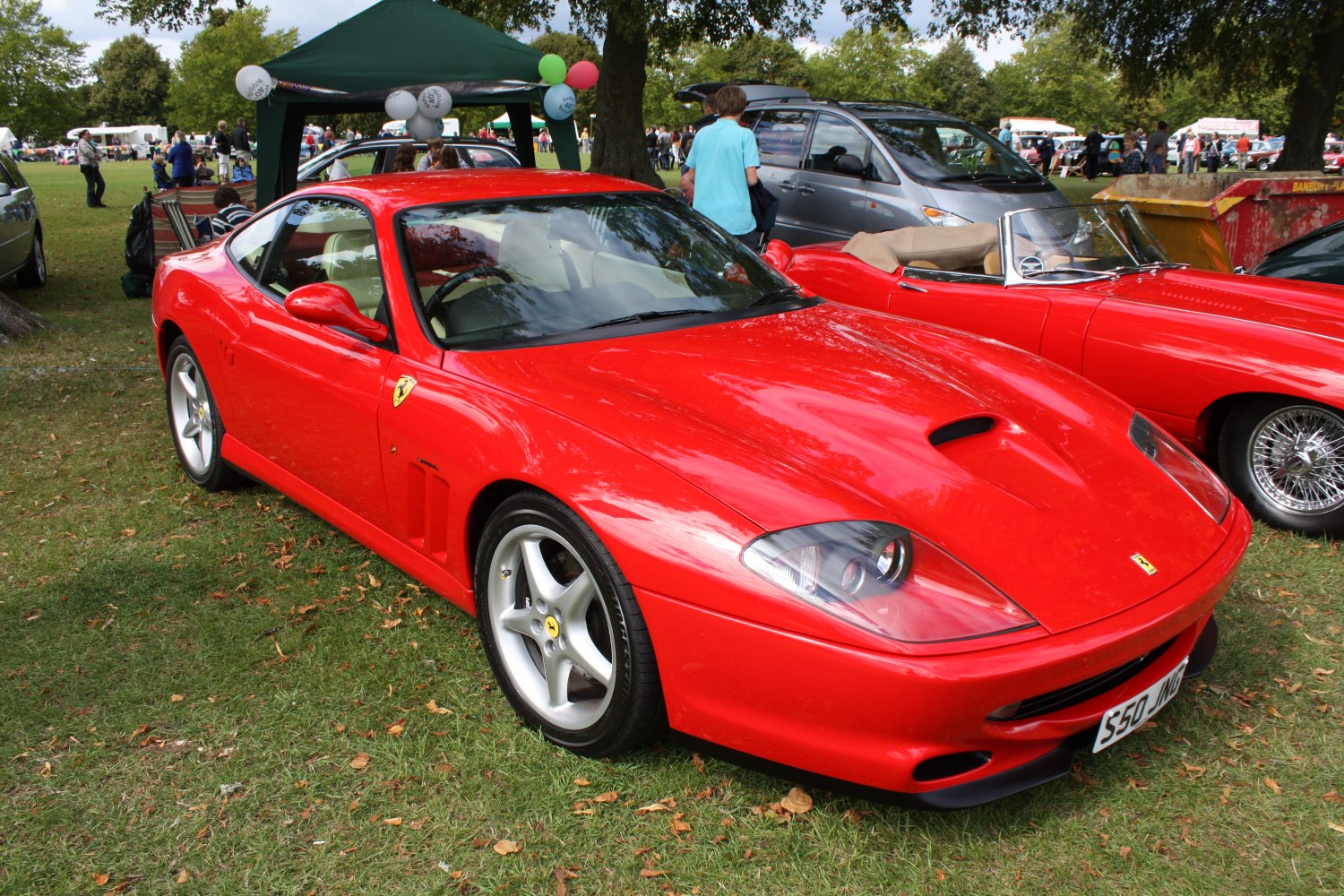 Red sports coupe with hood scoop and aerodynamic styling.