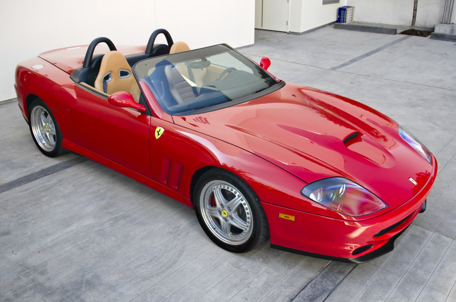 Red convertible with aerodynamic hood scoop and tan bucket seats