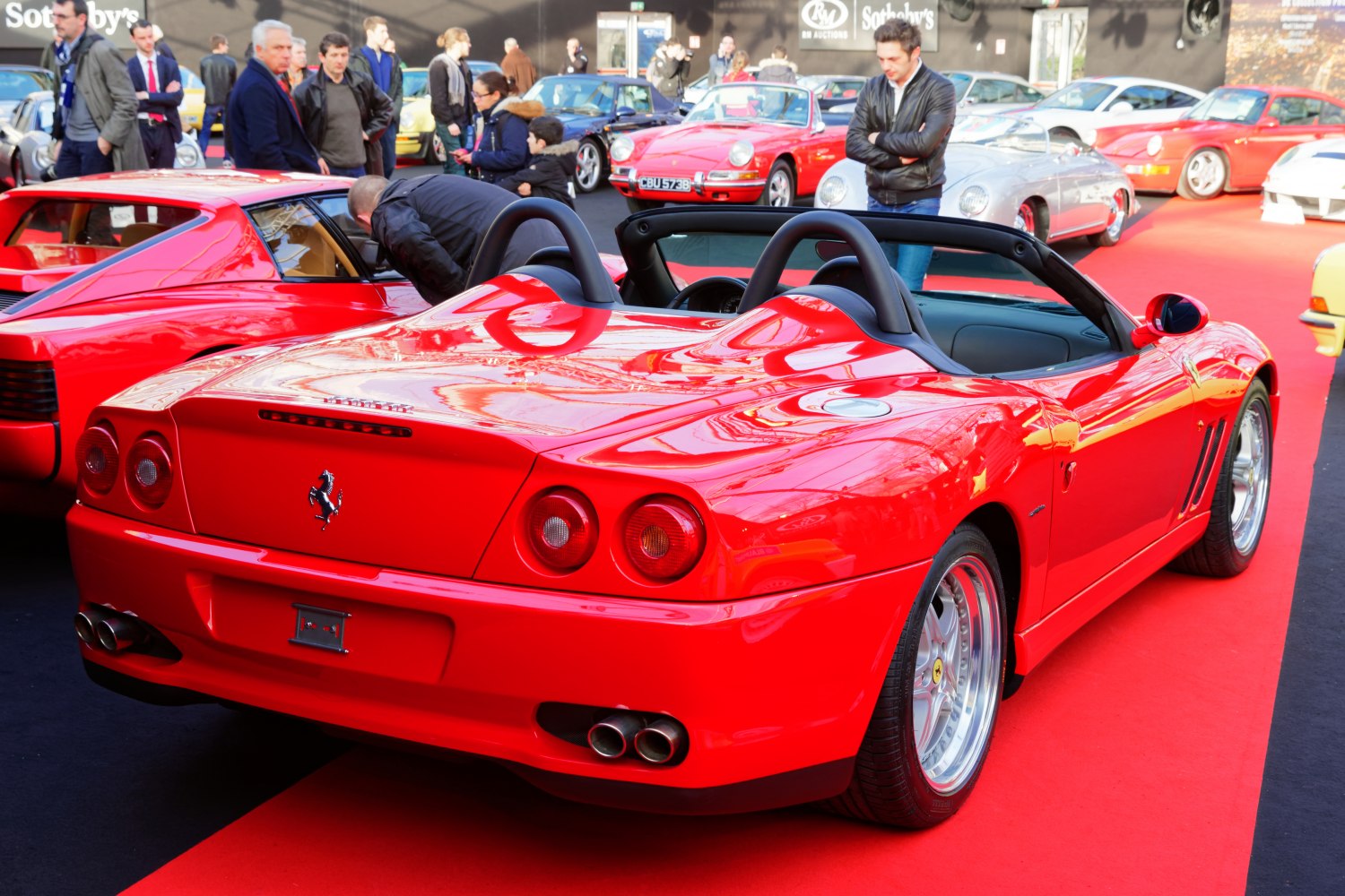 Red convertible roadster with dual roll bars and round taillights