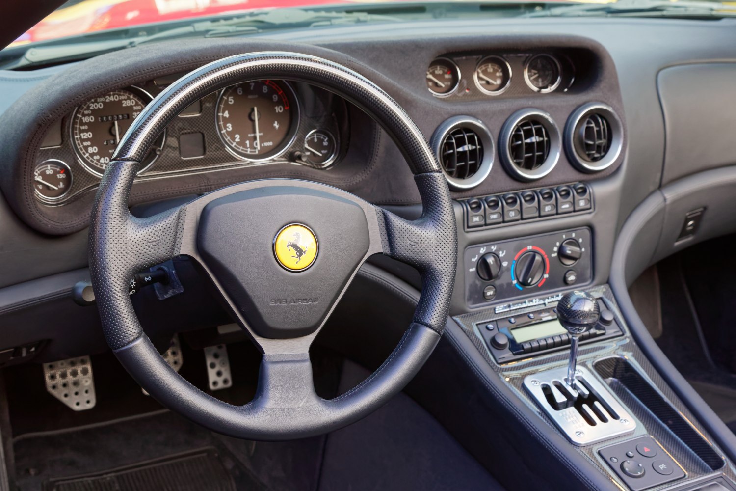 Steering wheel, gauge cluster, manual gear shifter, and dashboard controls