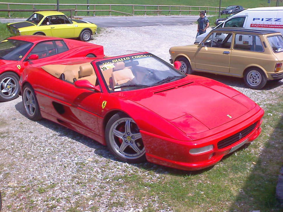 Red convertible sports car with distinctive Ferrari design and alloy wheels.