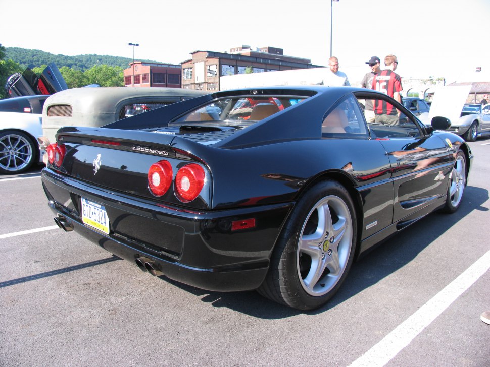 Rear and side view of a black sports coupe with distinctive round taillights.
