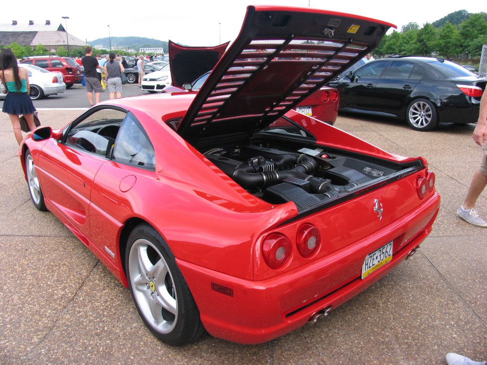 Rear view of red sports coupe with open engine compartment.