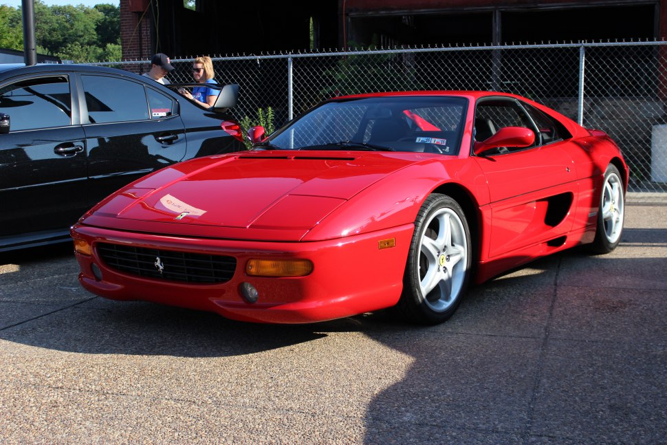 Sleek red sports car with five-spoke wheels and aerodynamic front design