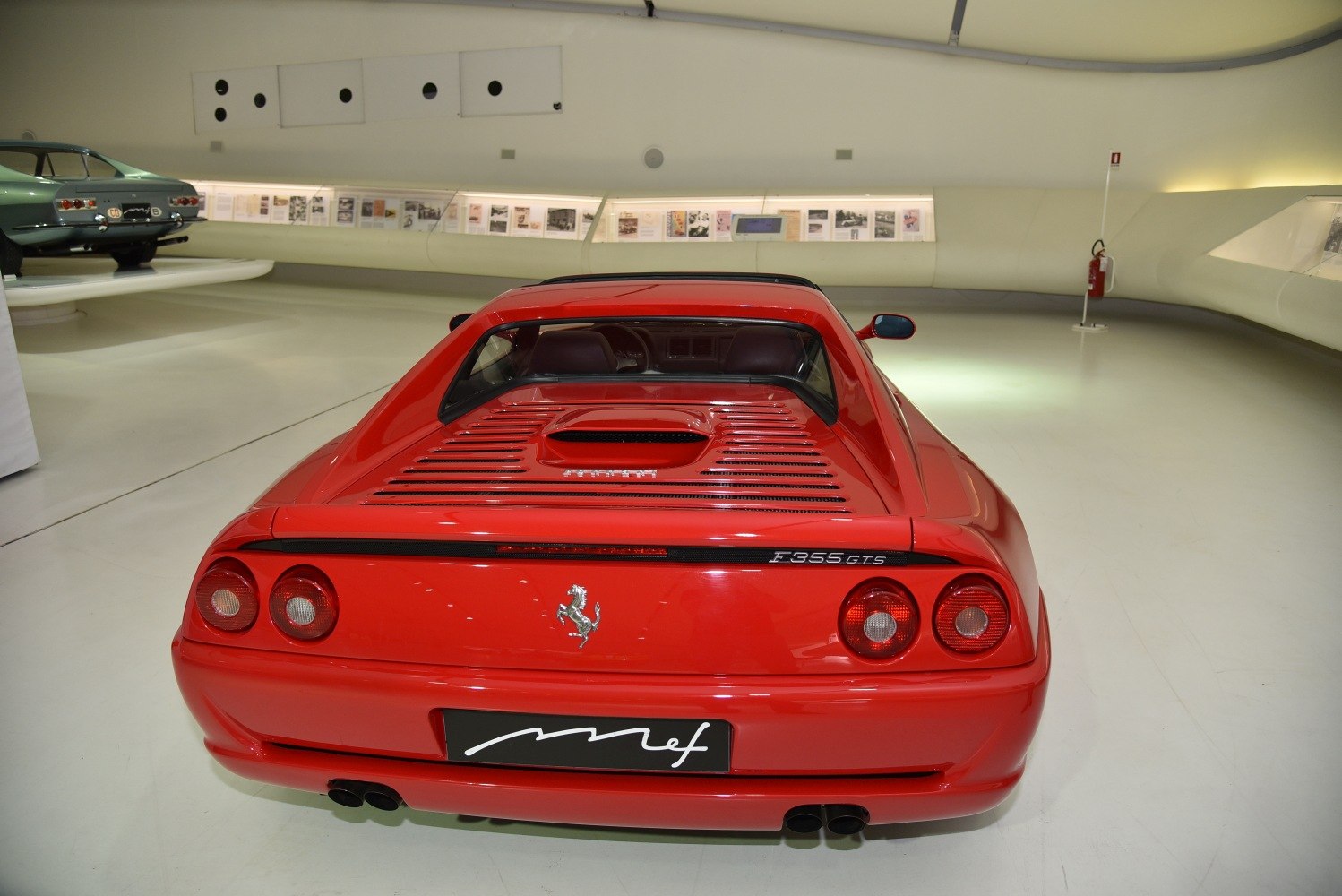 Rear view with taillights, engine cover slats, quad exhaust