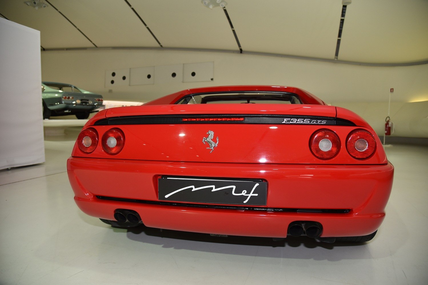 Red Ferrari F355 GTS rear featuring circular taillights and dual exhaust setup