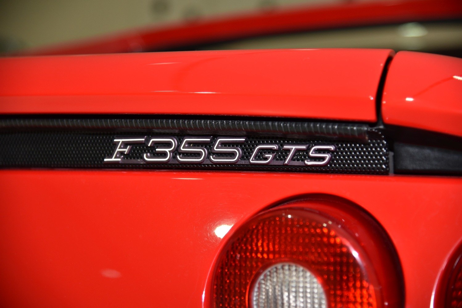 Close-up of rear badge and taillight on red sports car