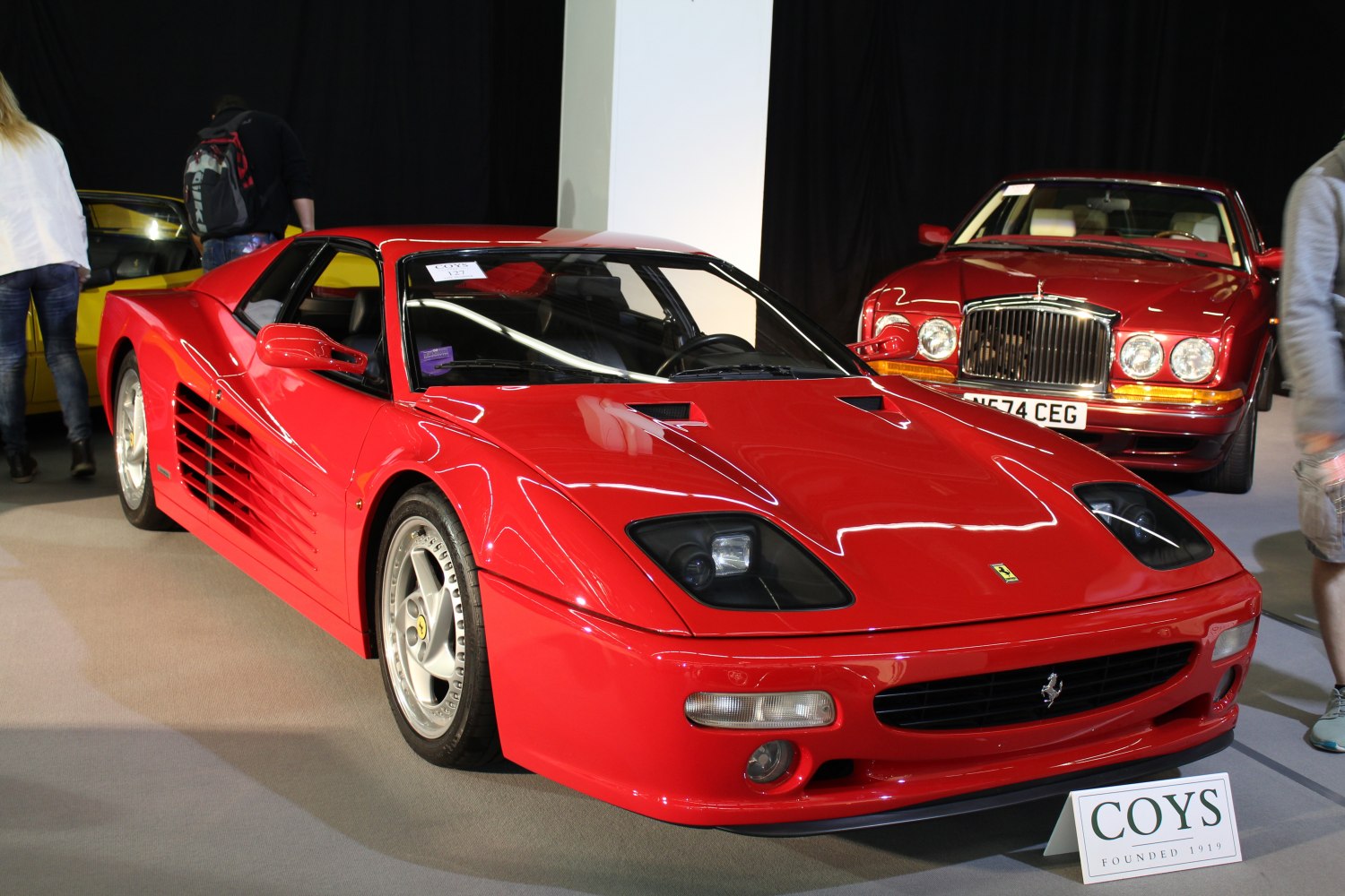 Red mid-engined sports coupe with pop-up headlights and side air vents