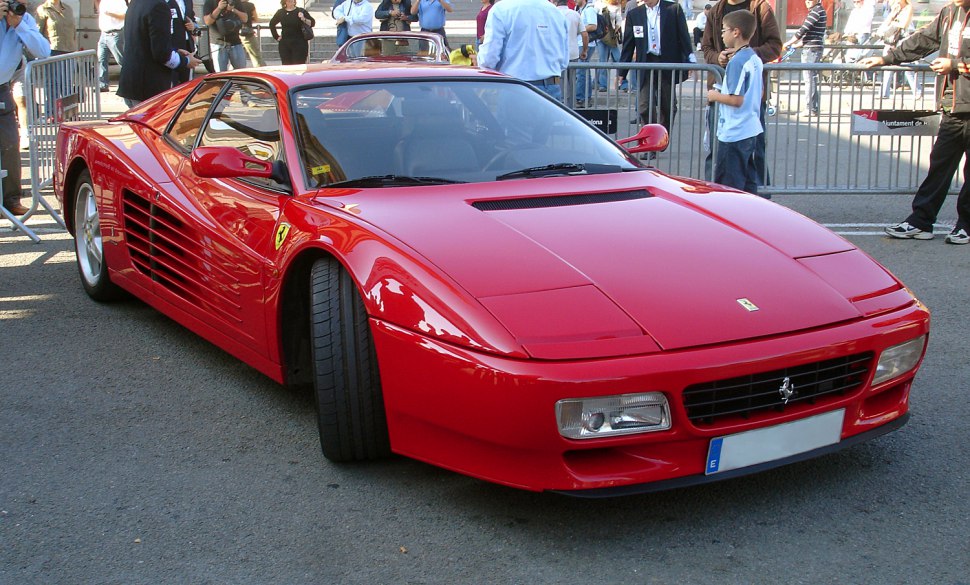 Front view of red Ferrari with side strakes and pop-up headlights