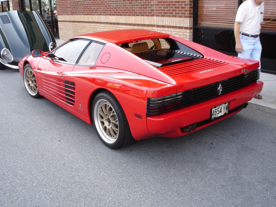 Rear and side view with louvered rear grille and mid-engine design.
