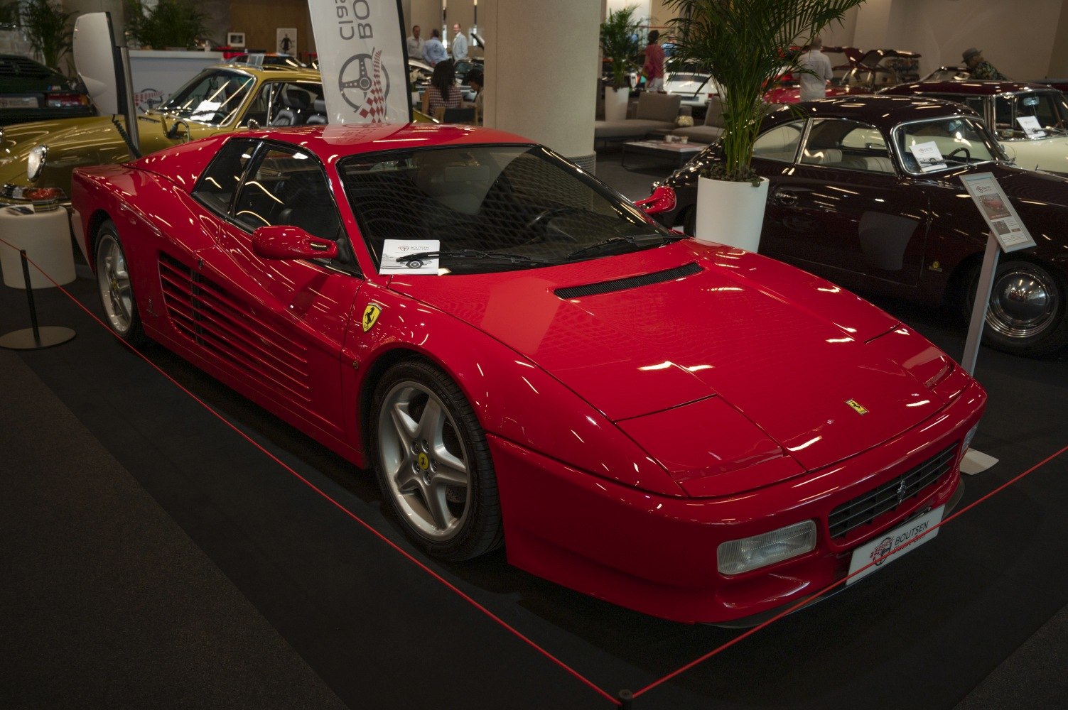 Red wedge-shaped sports car with side strakes and five-spoke wheels
