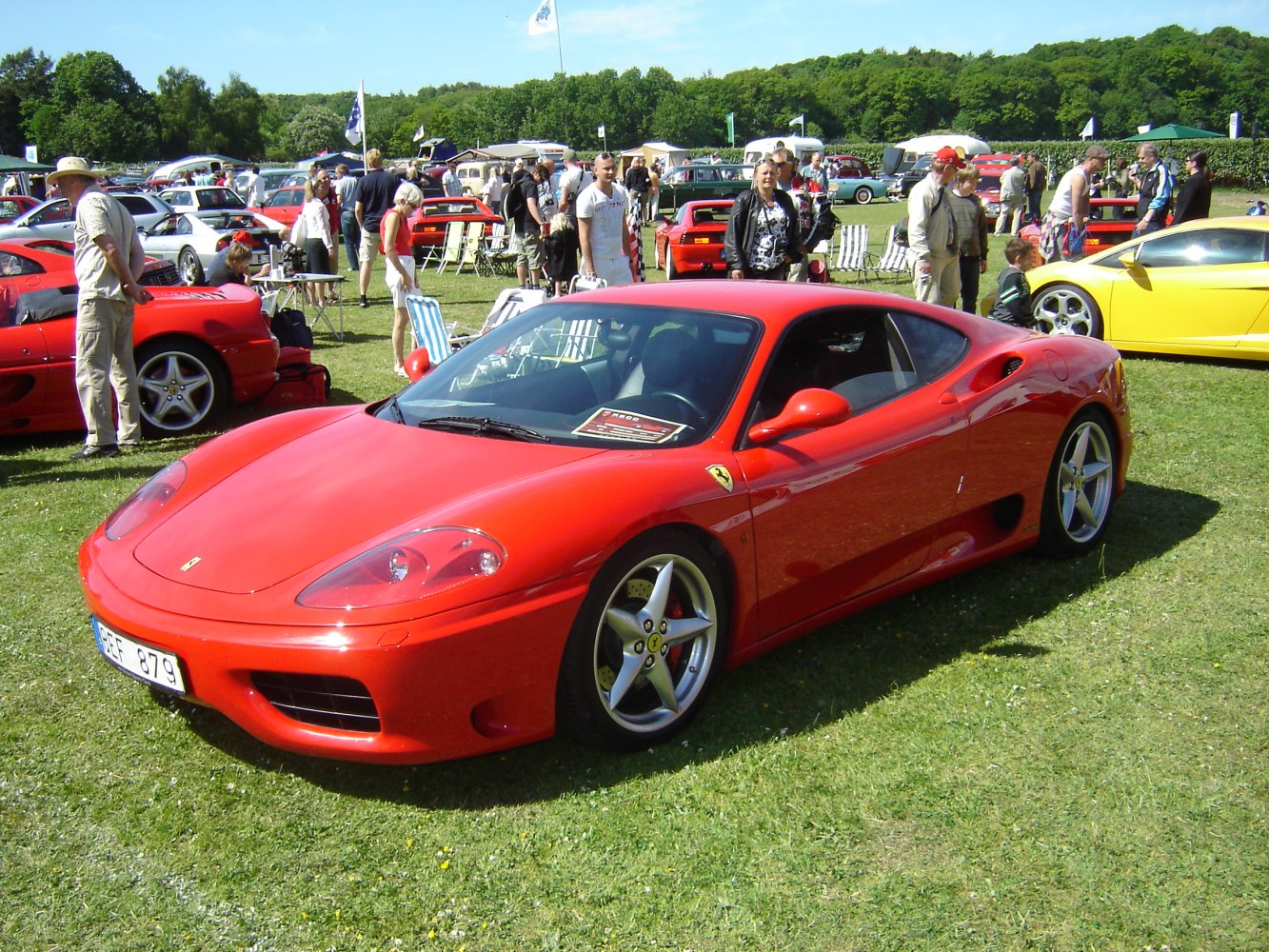 Red mid-engine sports coupe with sleek aerodynamic curves and alloy wheels