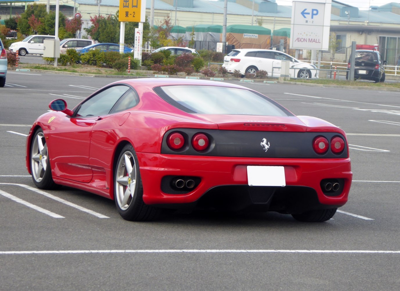 Red sports coupe rear with round tail lights and dual exhausts