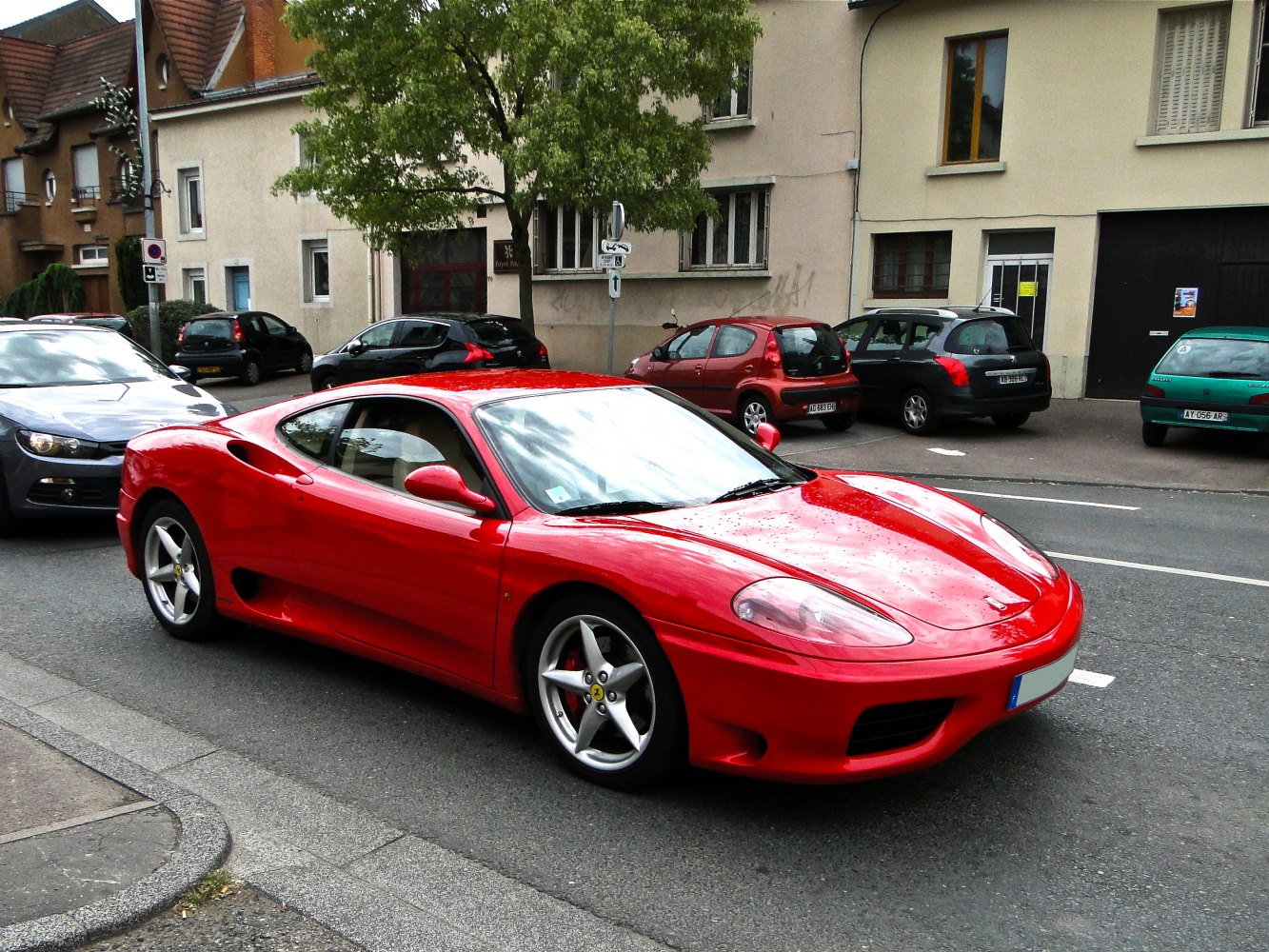 Red sports coupe with sleek design and five-spoke alloy wheels