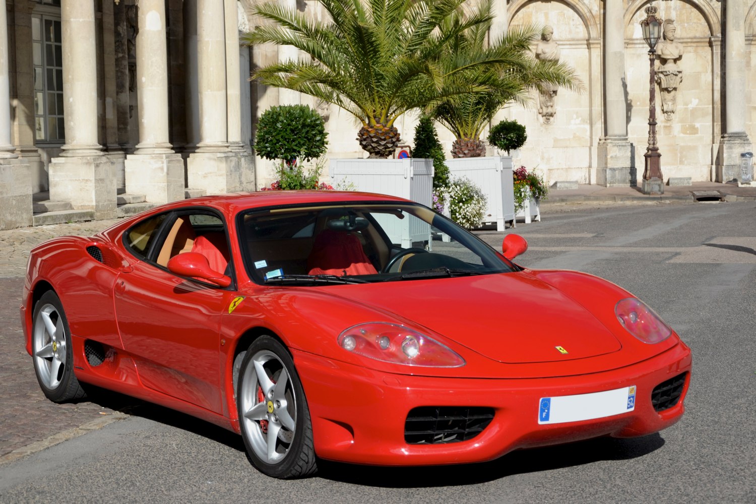 Red sports coupe front side view with sleek aerodynamic design and alloy wheels
