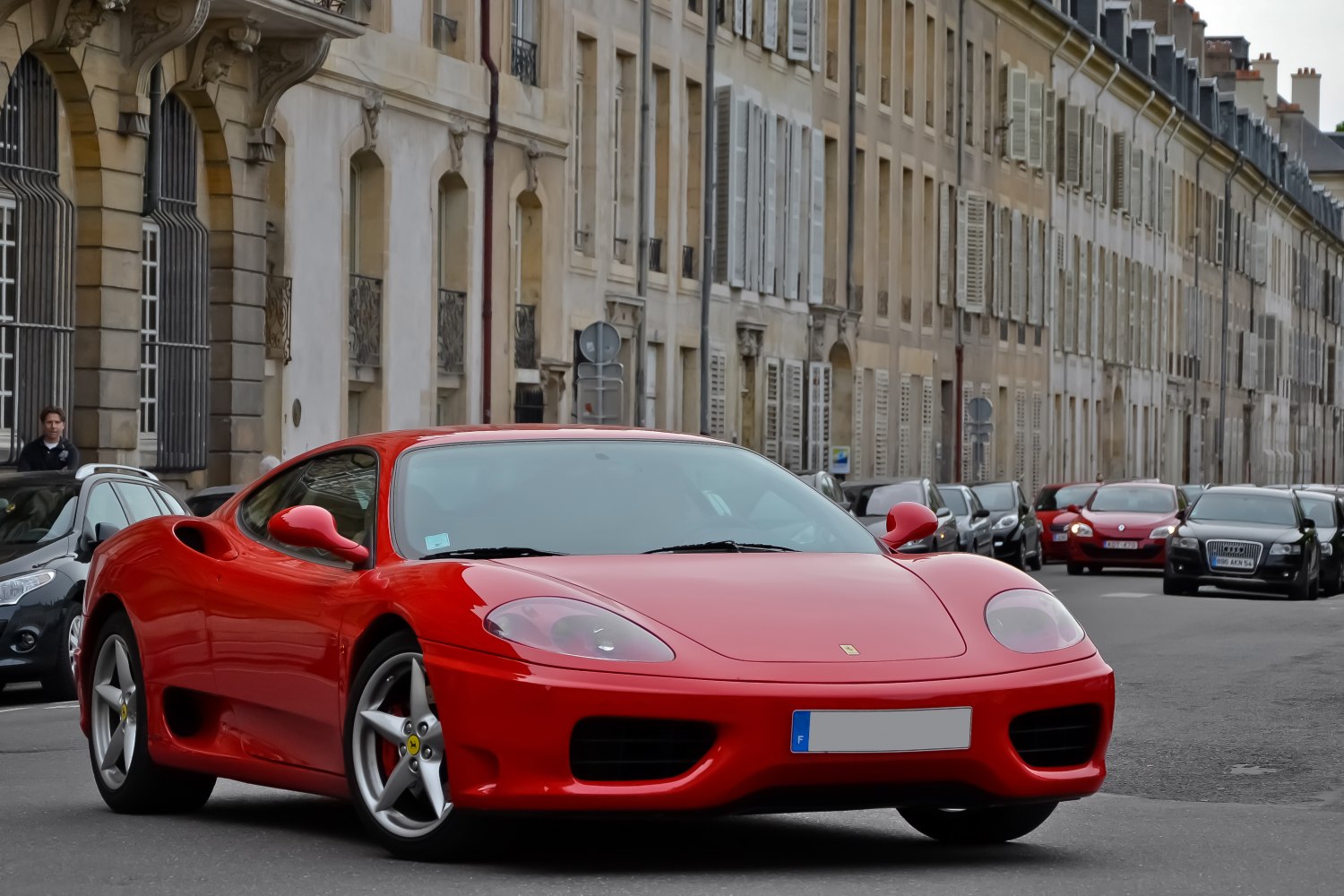 Red aerodynamic sports coupe with five-spoke wheels and distinctive headlights