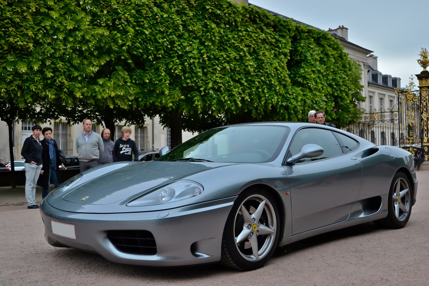 Silver sports coupe with distinctive headlights and five-spoke alloy wheels