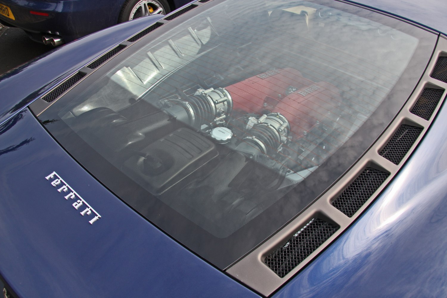 Mid-engine V8 visible through rear window with surrounding vents and badge