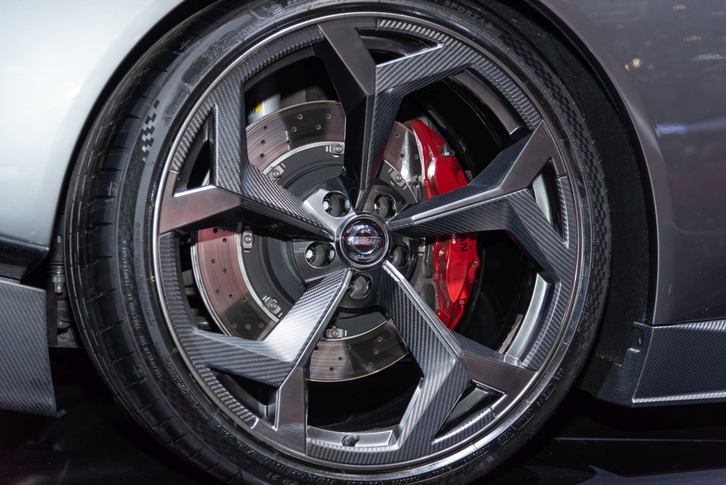 Carbon fiber wheel with drilled brake disc and red brake caliper