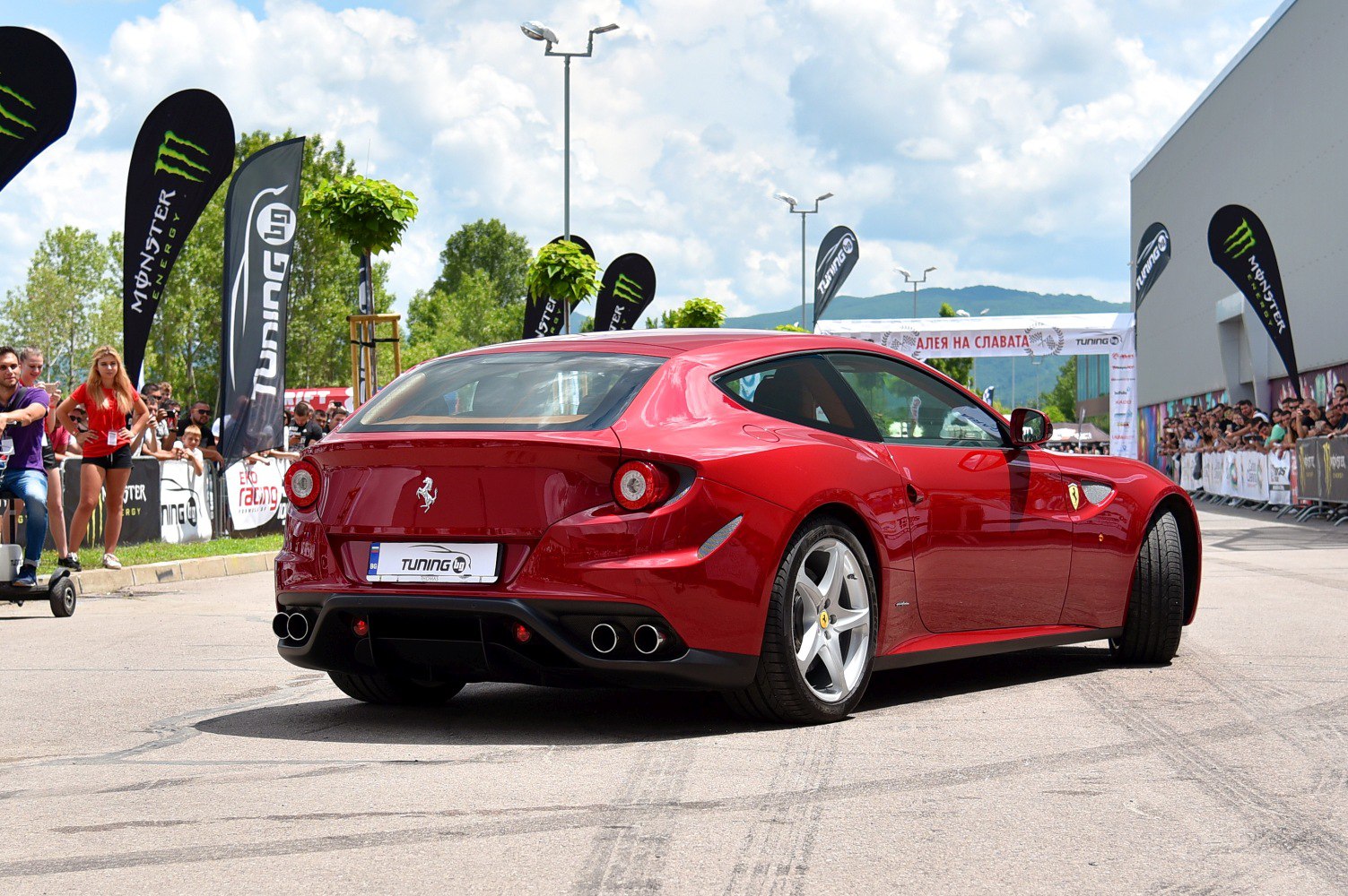 Red sports car rear side view with quad exhaust and unique tail lights