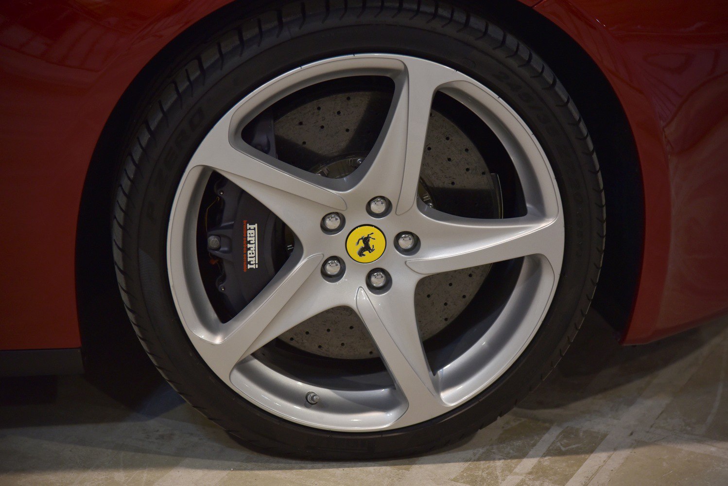 Close-up of alloy wheel with brake caliper and drilled disc brakes