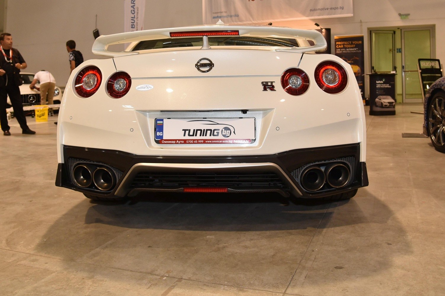 Rear view with signature round tail lights, quad exhaust, and large spoiler