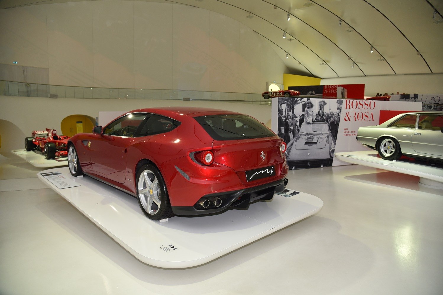 Rear view of a luxury sports car featuring round tail lights and quad exhausts.