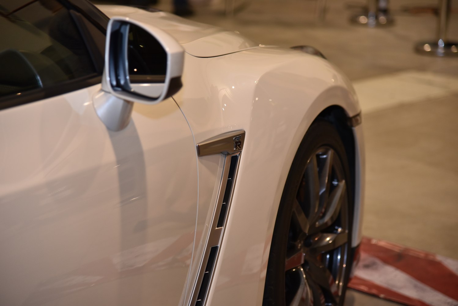 Side vent detail and alloy wheel rim with side mirror on car body