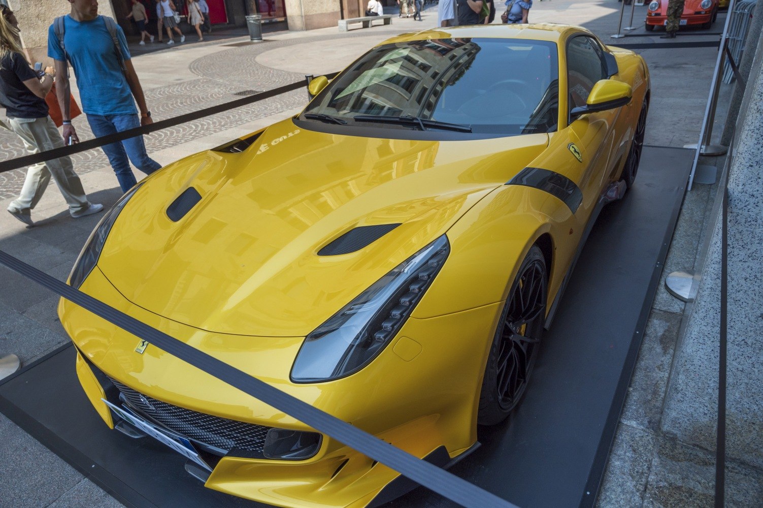 Aerodynamic vents and LED headlights on a yellow sports car front.