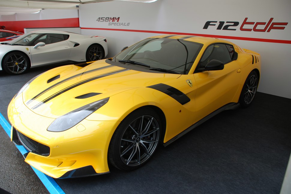 Yellow Ferrari F12tdf with black racing stripes and aerodynamic front splitter