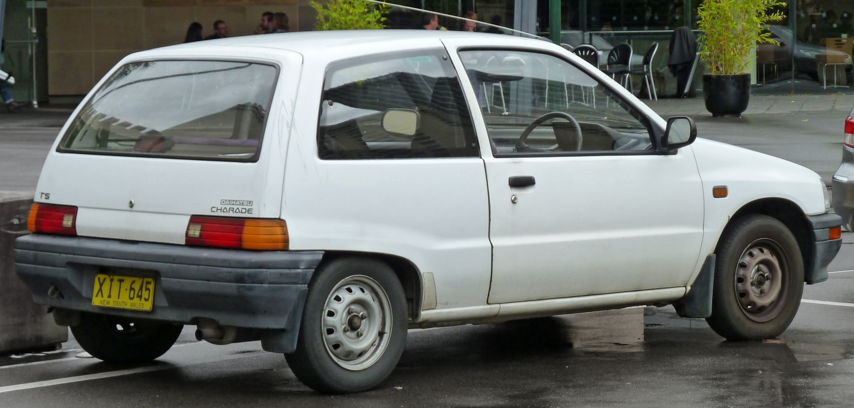 White three-door hatchback rear view with compact design and steel wheels