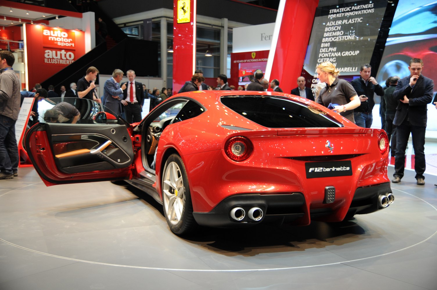 Rear view of red sports coupe with open door and round taillights