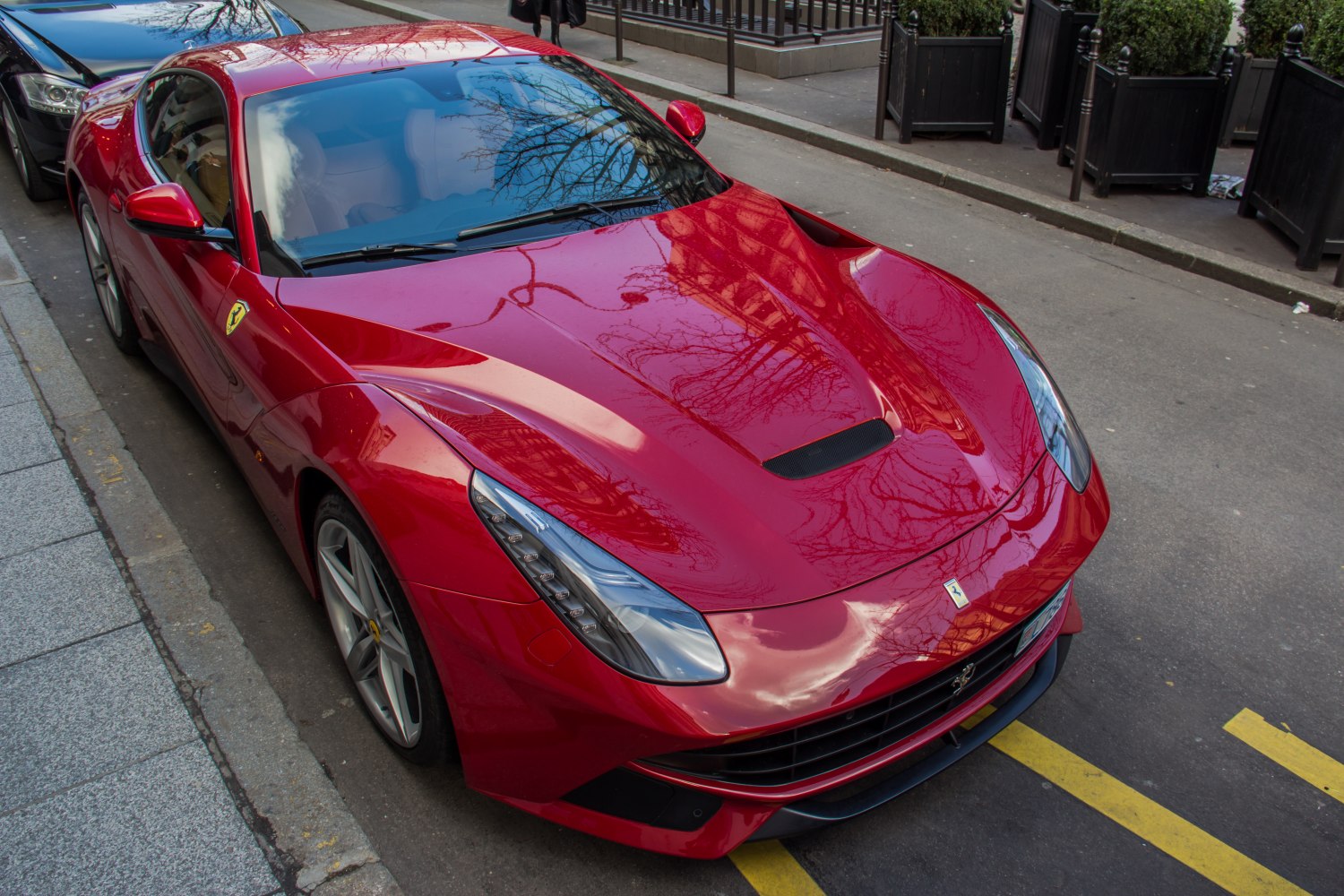 Red sports coupe with aerodynamic hood vents and sharp LED headlights.