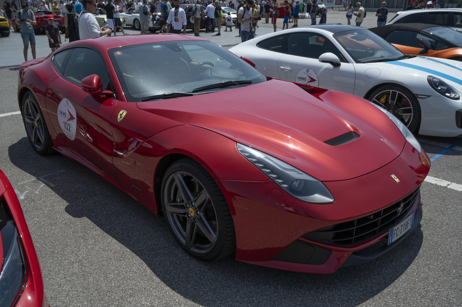 Front and side view of a red sporty coupe with aerodynamic vents and low stance.