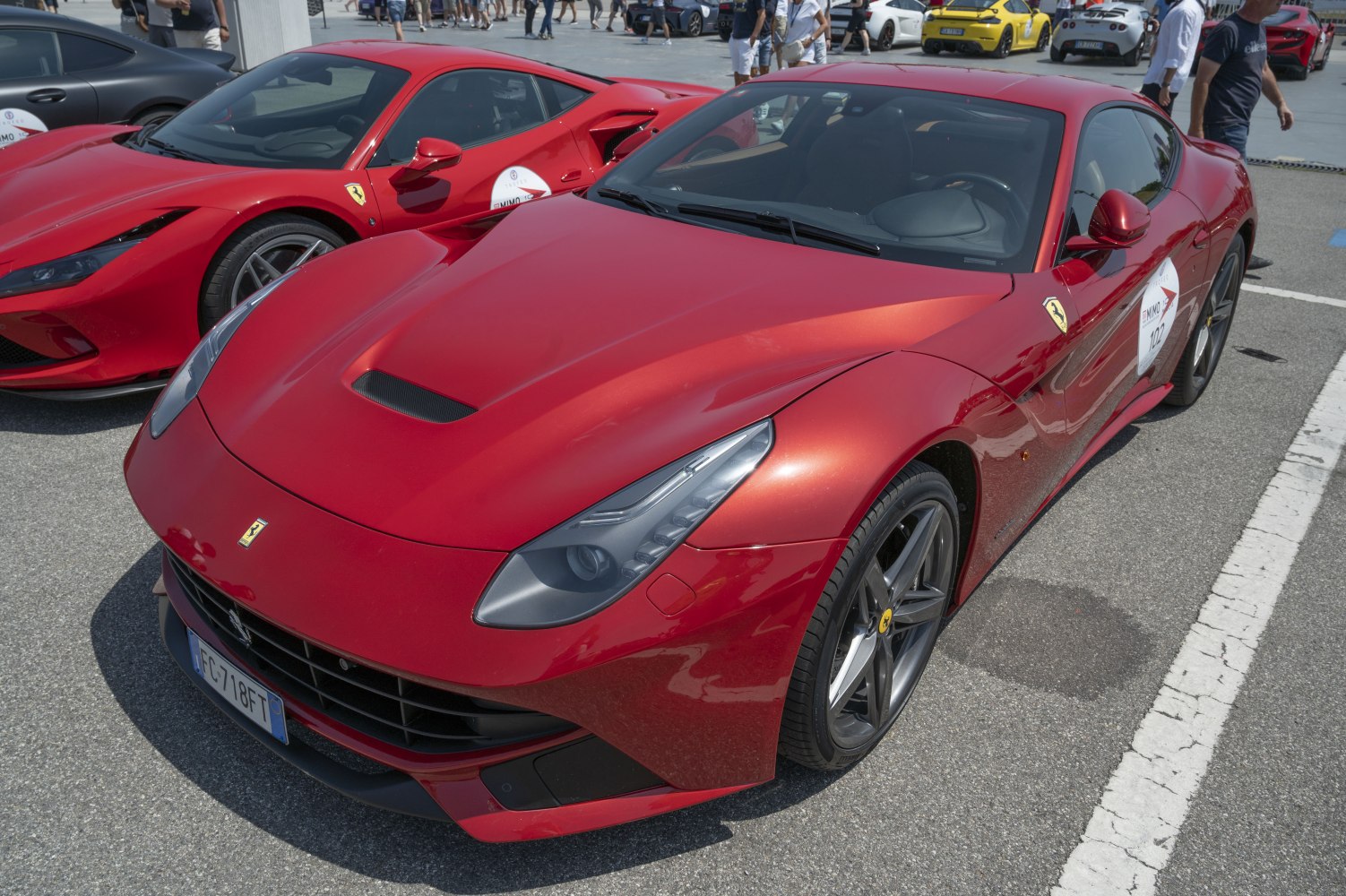 Red sports coupe front with sleek headlights and hood vent