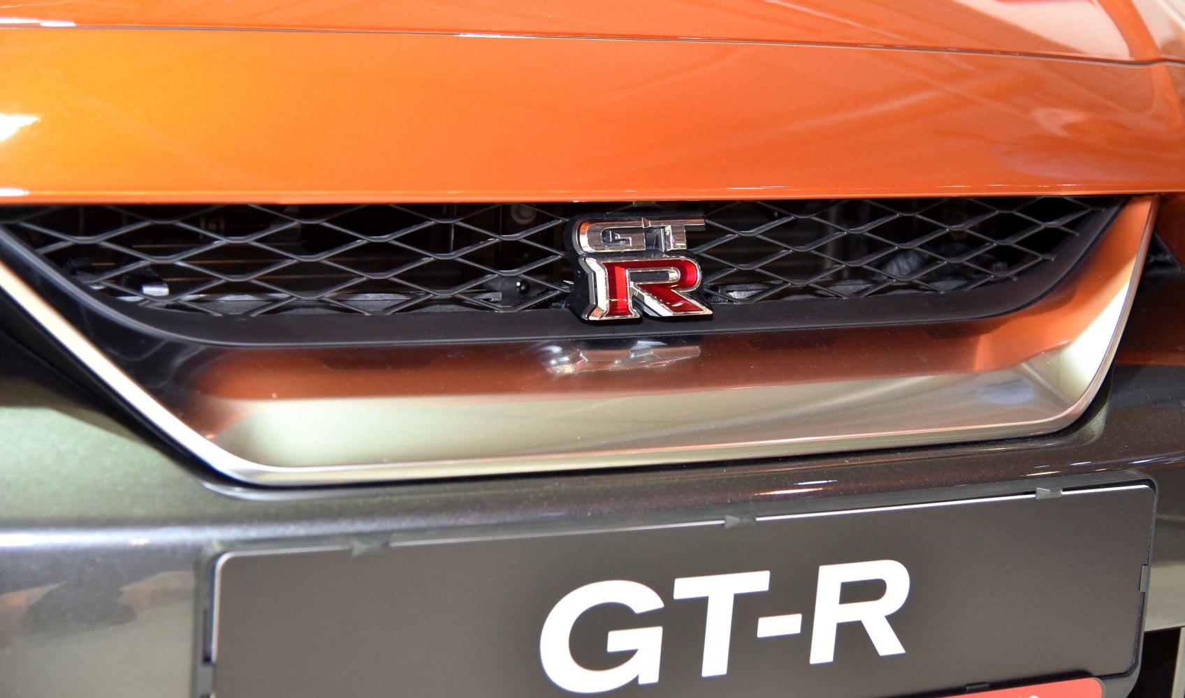 Close-up of front grille and GT-R emblem in facelifted Nissan model.
