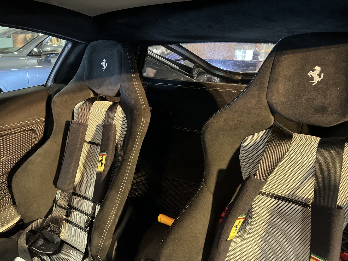 Racing bucket seats with harnesses and Ferrari logos